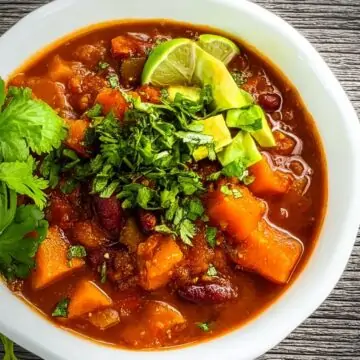 Hearty bowl of Smokey Butternut Chili with avocado and lime